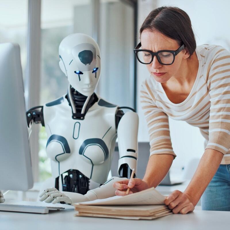 een persoon en een robot die aan een bureau zitten