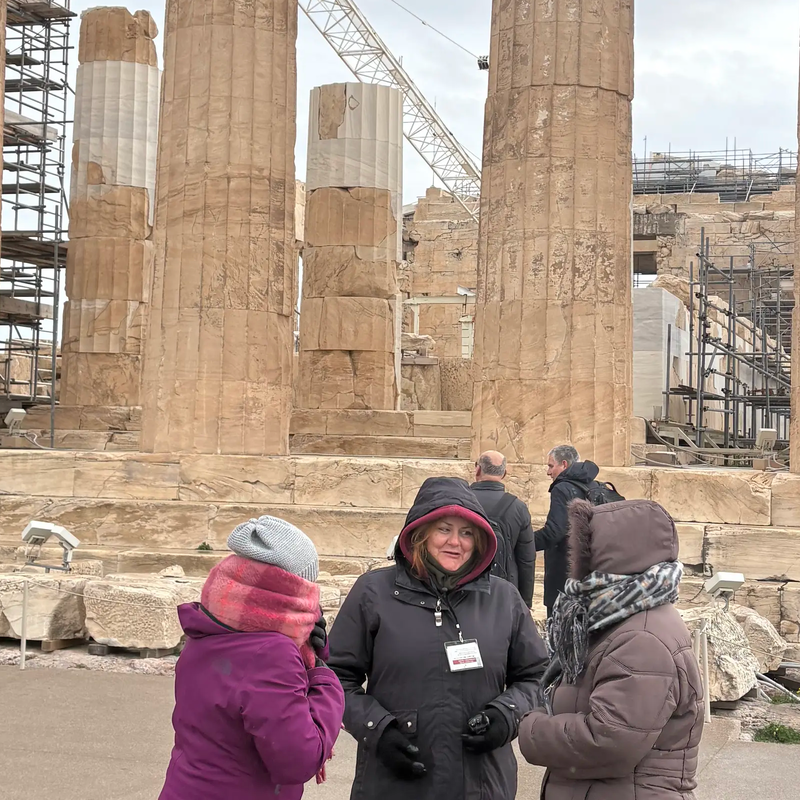Een groep mensen die zich voor een gebouw bevinden